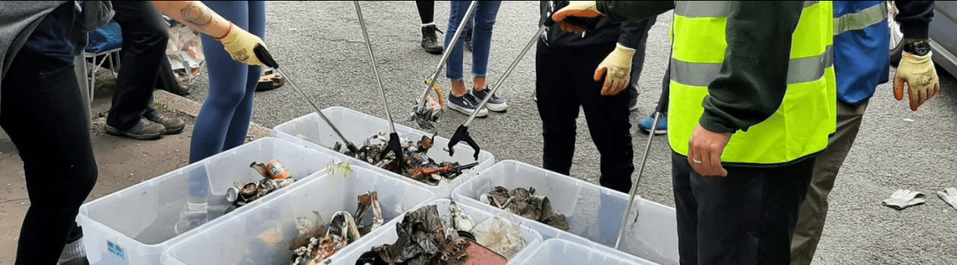 Volunteers participating in a river clean-up event on the banks of the River Mersey.